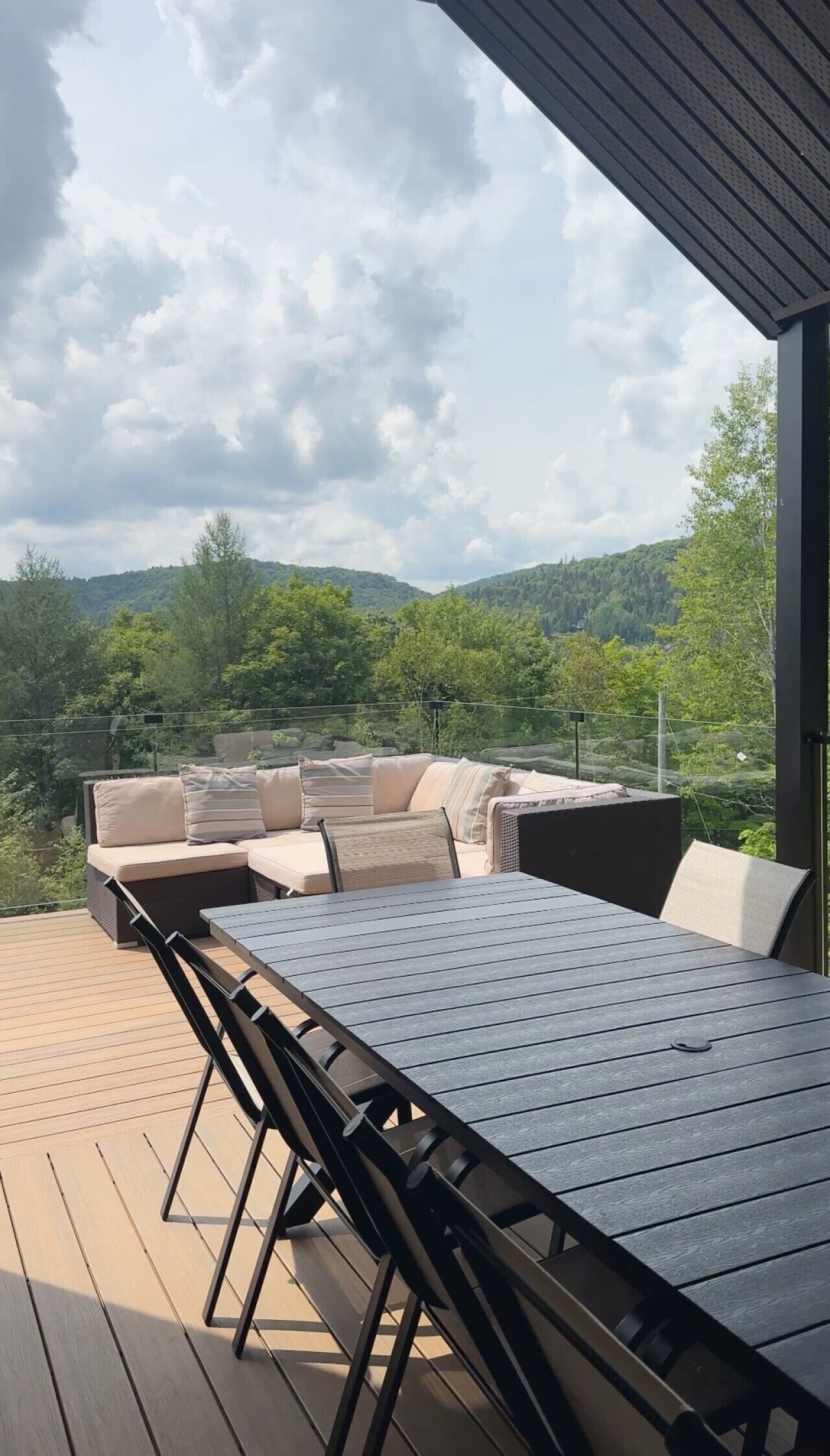 Une terrasse extérieure avec une table et des chaises, offrant une vue sur un paysage montagneux.