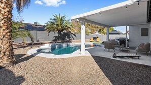 A covered outdoor area with a swimming pool, patio furniture, and a pergola. - Summer Deal! Pool Home! Fast WiFi! Relocating! (Phoenix)