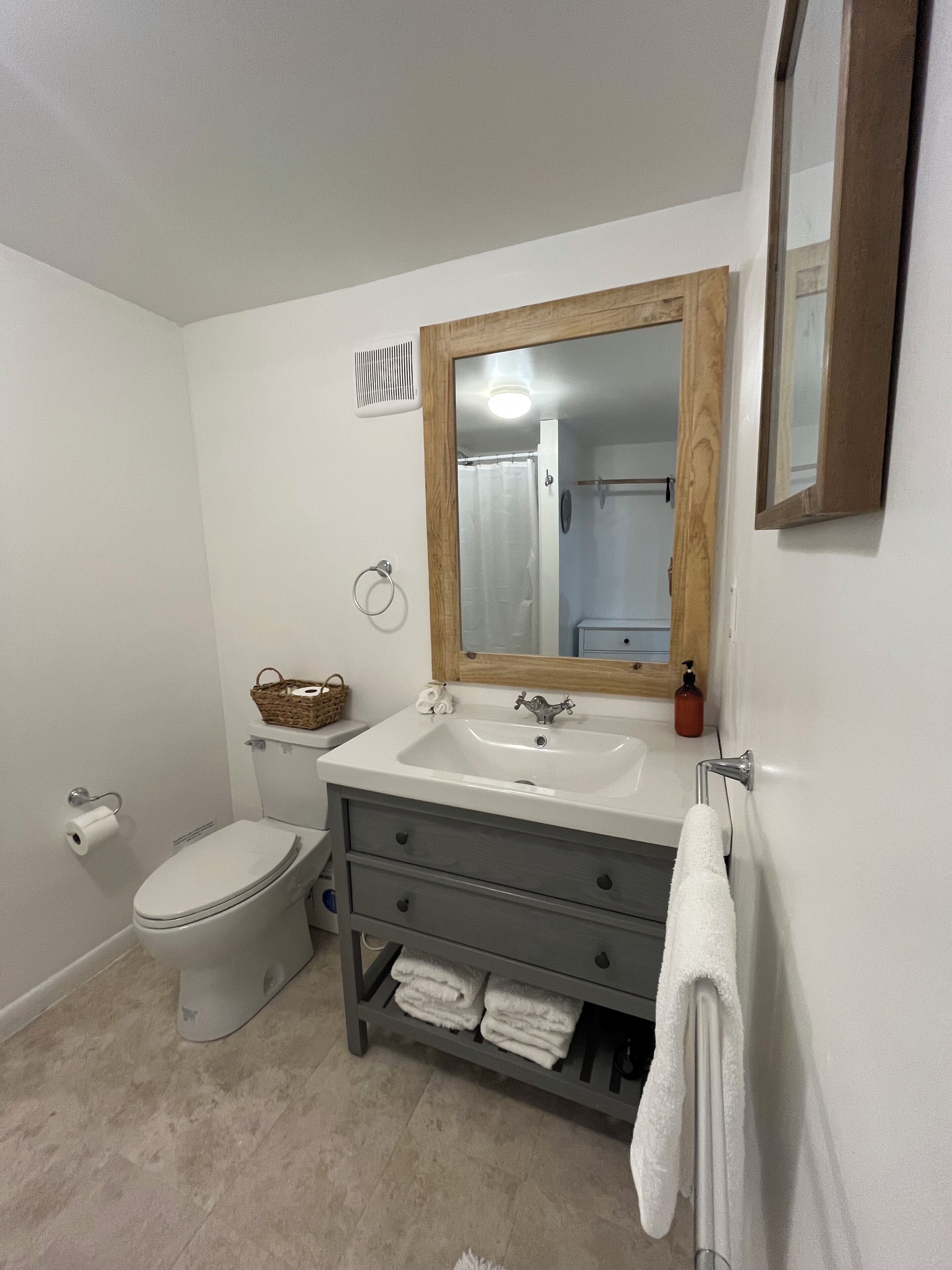 Un baño con inodoro, lavabo y espejo.