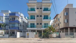 A multi-story hotel with balconies, a central entrance, and a gated driveway. - 2-bedroom Apt 550m From the Beach Chv0102 (Florianópolis)