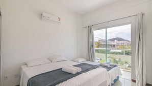 A bedroom with a bed, a window, and an air conditioning unit. - 2-bedroom Apt 550m From the Beach Chv0102 (Florianópolis)