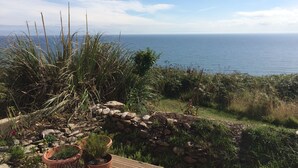 Un jardin agrémenté de plantes en pot et offrant une vue sur la mer.