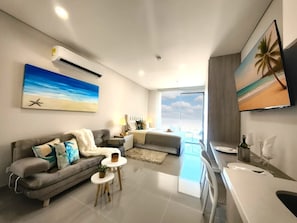 A modern living room with a sofa, a coffee table, and a TV mounted on the wall.