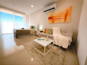 A modern living room with a sofa, a coffee table, and a painting on the wall.