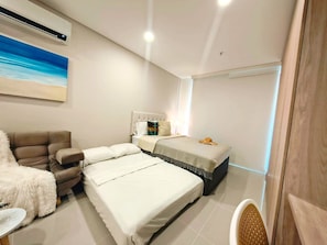 Une chambre à coucher moderne avec un lit, un canapé et un fauteuil.