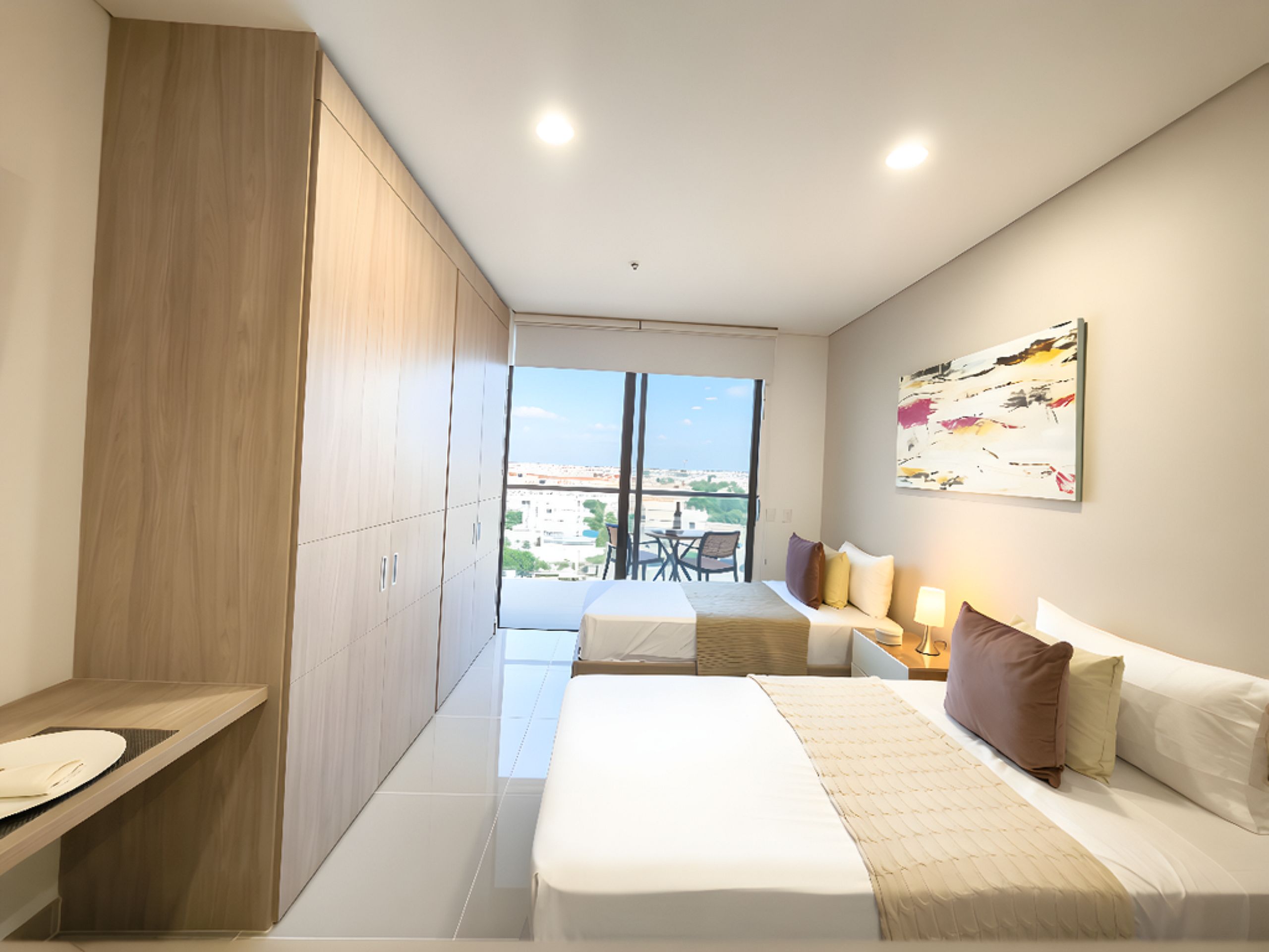 A modern bedroom with a bed, bedside table, and a view of the city through large windows.