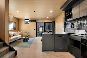 Una cocina moderna con lavavajillas, un comedor con sofá y vistas al exterior.