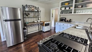 A modern kitchen with a stainless steel refrigerator, a gas stove, and a built-in oven. - Private Ranch House, Highland Cattle, Horses & Peaceful Views - a soul refresher (Myrtle Creek)