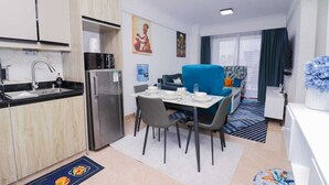 Una habitación de hotel compacta con kitchenette, comedor y sala de estar.