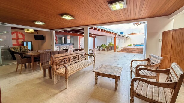 Un espace intérieur spacieux, aménagé avec des meubles en bois, une table à manger et un coin cuisine visible à travers une porte ouverte.