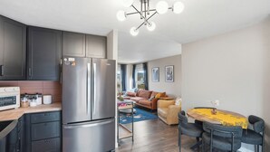 Une cuisine moderne dotée d’un réfrigérateur en acier inoxydable, de meubles en bois et d’un four encastré.