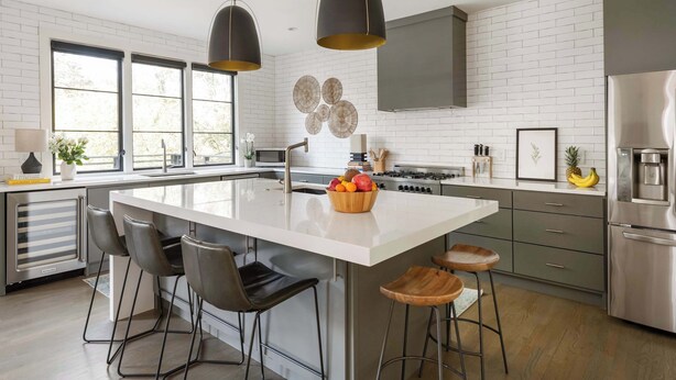 A modern kitchen with a central island, bar stools, and stainless steel appliances. - Le Reve (Atlanta)