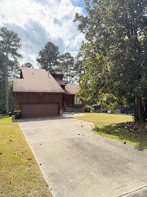 A two-story house with a garage, a front lawn, and a driveway. - LAKE DAZE 4-bedroom Lakefront home in quiet cove on Pea Hill Creek (Henrico)