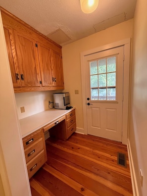 A compact kitchen with wooden cabinets, a countertop, a microwave, and a door with a window. - LAKE DAZE 4-bedroom Lakefront home in quiet cove on Pea Hill Creek (Henrico)