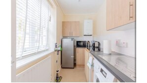 Cocina compacta con refrigerador, microondas y lavadora.