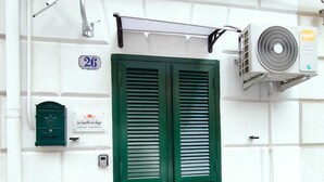 A green door with a window, a mailbox, and an air conditioning unit on the wall. - Angy's Little House is a small abode a 10-minute walk from downtown (Palermo)