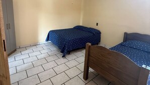 Camera da letto con due letti, un armadio e una lampada a soffitto.