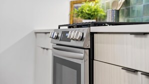 Una cocina moderna con estufa de acero inoxidable, microondas y horno empotrado.