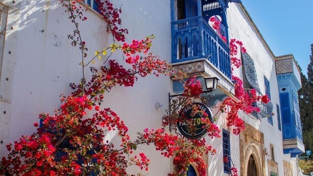 A traditional white building with blue accents and a sign indicating a restaurant. - Maison Lella Kmar Sidi Bousaid (Site archéologique de Carthage)