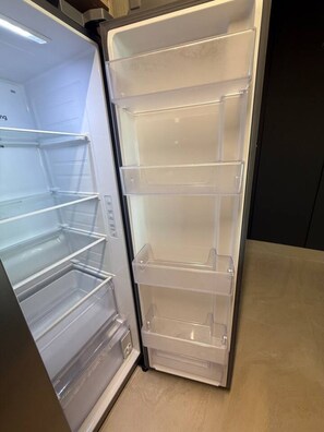 An open refrigerator with multiple shelves and a freezer compartment.