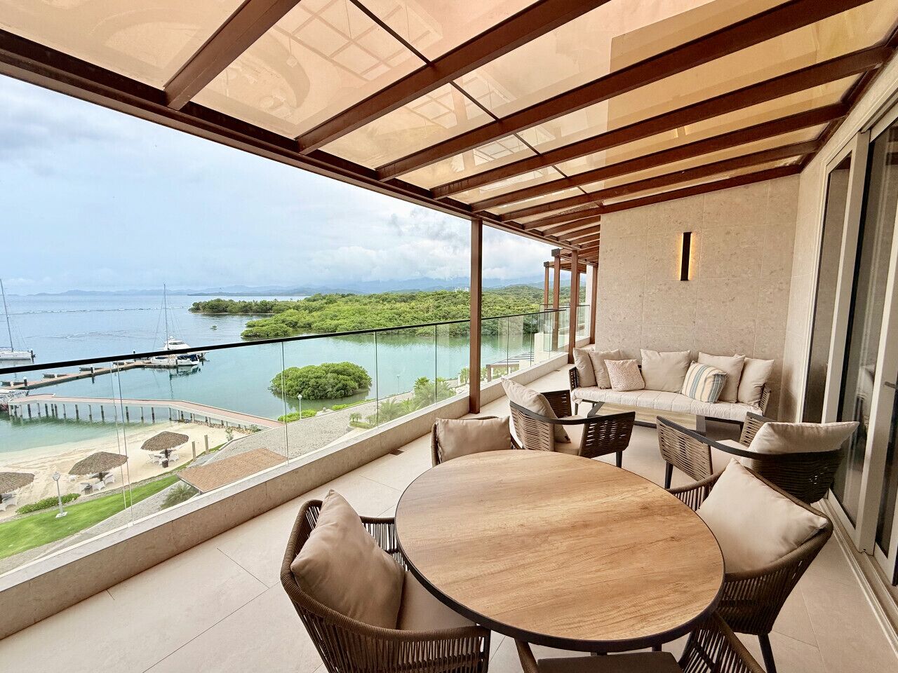 Penthouse balcony featuring an outdoor dining table, seating area, and direct ocean views.