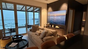 A modern living room with a large sofa, a coffee table, and a TV displaying 'AFRO HOUSE'.
