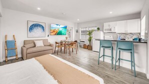 A modern apartment with a living room, dining area, and kitchen. - Hawksbill 201 | Beach Studio | Heated Pool (Lauderdale-by-the-Sea)