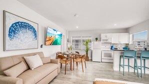 A modern apartment with a living room, dining area, and kitchen. - Hawksbill 201 | Beach Studio | Heated Pool (Lauderdale-by-the-Sea)