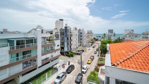 Un immeuble résidentiel à plusieurs étages, doté de balcons, d’un parking et offrant une vue sur la mer.