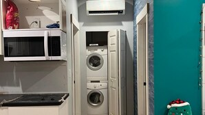 A compact kitchen with a microwave, oven, and a washing machine. - Secondary private 1 bdrm / 1 bath suite in Fanny Bay (Comox Valley A)