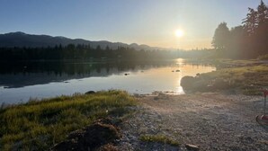 A serene lakeside view with mountains in the background and a clear sky. - Secondary private 1 bdrm / 1 bath suite in Fanny Bay (Comox Valley A)