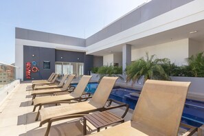 A rooftop pool area with lounge chairs, a lifebuoy, and a signboard. - U-GO Edificio Ambar Roca en Rodadero Sur (Santa Marta)