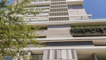 A high-rise building with multiple floors, balconies, and a sign that reads 'AM.'