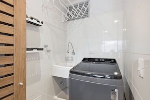 A laundry area with a washing machine, a sink, and a shower. - U-GO Edificio Ambar Roca en Rodadero Sur (Santa Marta)