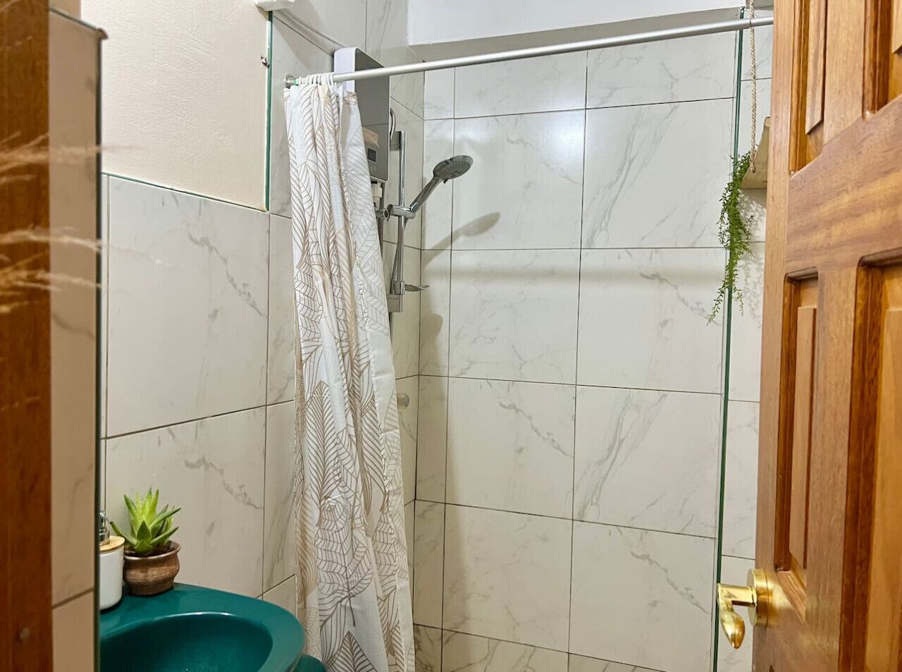 Une salle de bain avec une douche, des toilettes et un lavabo.