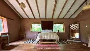 A bedroom with a wooden bed, a window, a ladder, and a wooden floor. - 1BR Country Home w/ Garden & Mountain View (Taray)
