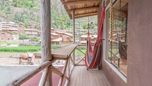 A wooden balcony with a hammock, a view of a mountainous area, and a building with a corrugated roof. - Bright Studio w/ Views, Top Wifi (Písac)