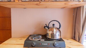 A stove with a kettle, control knobs, and a brand logo. - Bright Studio w/ Views, Top Wifi (Písac)