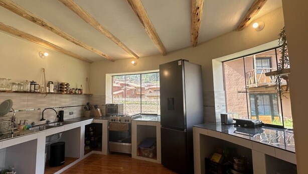 A modern kitchen with wooden beams, a large window, and a built-in oven.