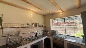 A kitchen with wooden beams, a large window, and a view of a traditional building.