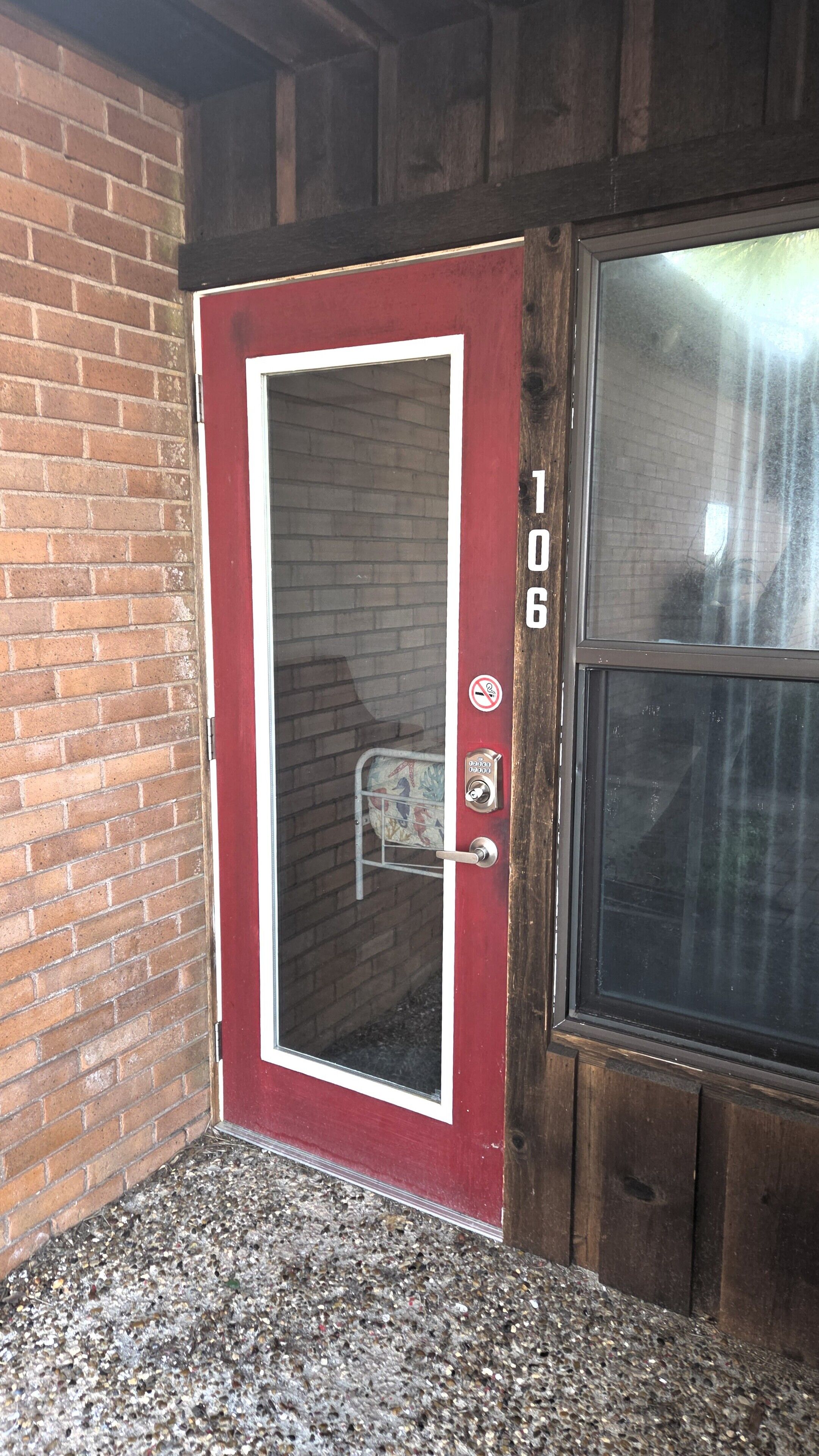 A red door with a glass panel, a metal handle, and a keypad lock.