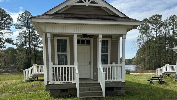 A single-story house with a front porch, a small deck, and a number '4' on the side. - Coles Point Marina (Hague)