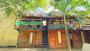 A wooden house with a thatched roof, a staircase, and a small balcony. - Mr Zamna Tulum (Tulum)