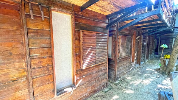 A wooden cabin with a porch, wooden shutters, and a gravel ground. - Mr Zamna Tulum (Tulum)