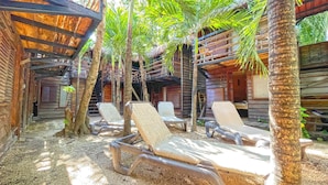 A tropical resort with wooden cabins, palm trees, and sun loungers. - Mr Zamna Tulum (Tulum)