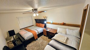 A bedroom with a bed, a desk, a chair, a ceiling fan, and a window with blinds. - Charming 2-bedroom bed & breakfast in serene Sioux Falls (Sioux Falls)