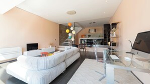 A modern living room with a sectional sofa, a glass coffee table, and a flat-screen TV.
