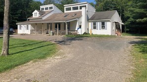 Een tweelaags huis met een veranda, een garage en een oprit naar de voordeur.