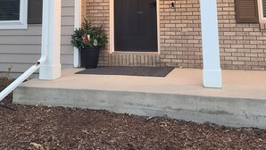 A two-story house with a front porch, a dark front door, and a small potted plant on the porch. - Timberline Retreat - Sleeps 9, large backyard, well stocked kitchen! (Windsor)