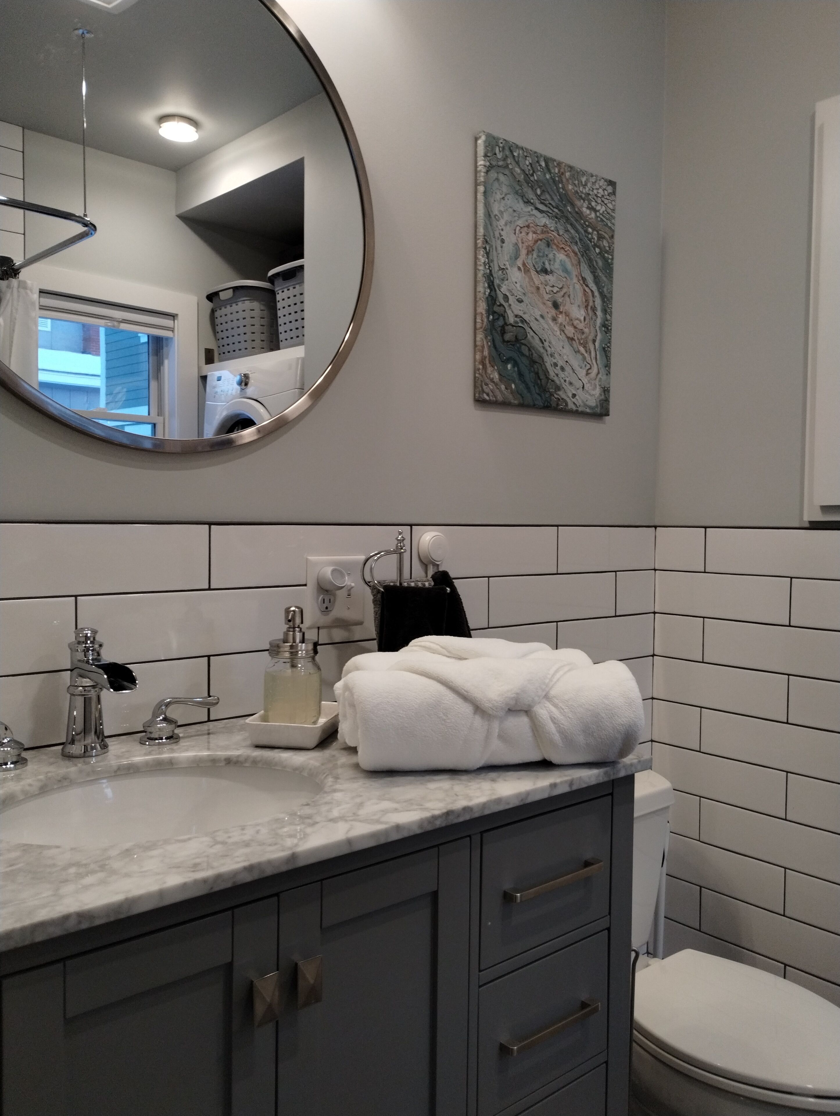 Une salle de bain avec un lavabo en marbre, une serviette, un distributeur de savon et des toilettes.